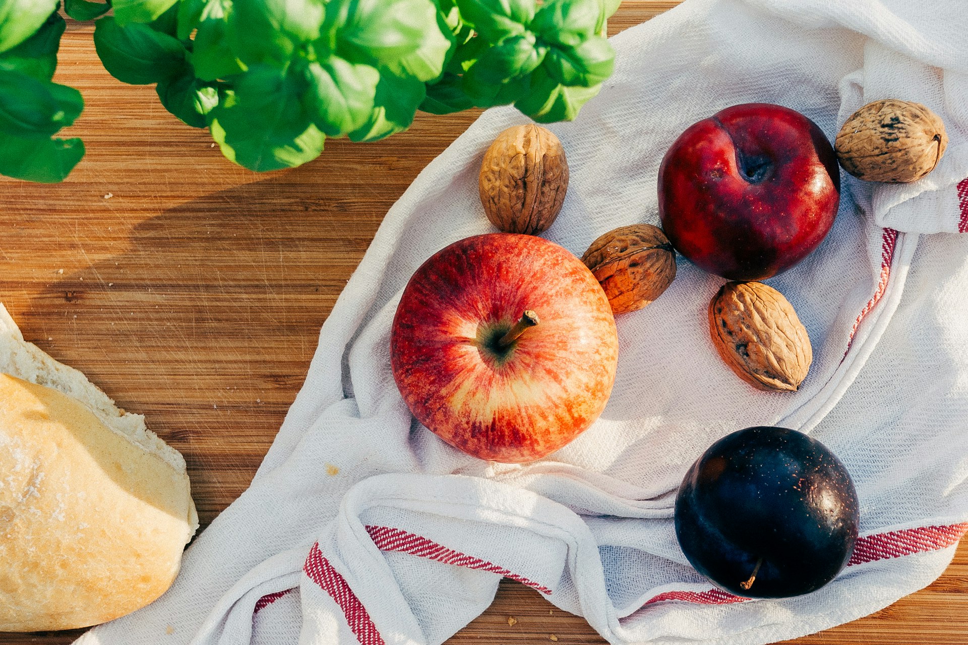 two apples and walnuts on white towel