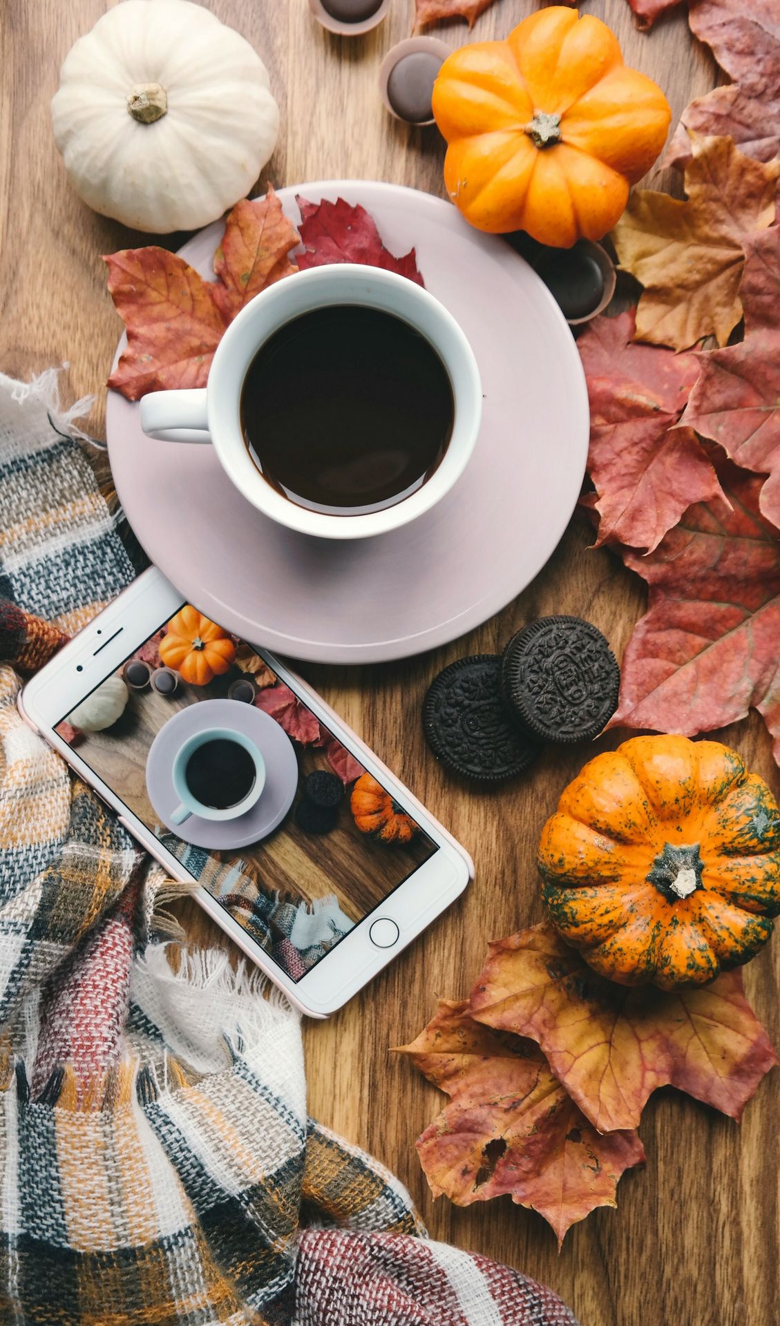 a cup of coffee and a cell phone on a table